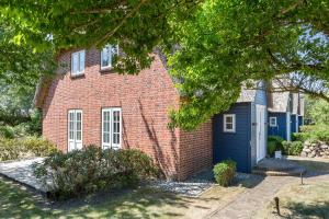 a red brick house with a blue garage at Haus Moevengrund in List