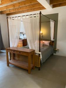a bedroom with a canopy bed with a mirror at Heerlijk Gaanderhei in Gaanderen