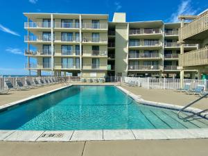 a swimming pool in front of a apartment building at Gulf Village 312 by ALBVR - Oversized balcony offers beautiful, unobstructed indirect views in Gulf Shores