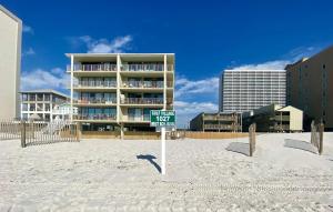 a street sign in the sand in front of a building at Gulf Village 312 by ALBVR - Oversized balcony offers beautiful, unobstructed indirect views in Gulf Shores