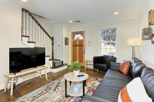 a living room with a couch and a flat screen tv at Beautiful 3br 2ba Colonial House CozySuites in Alexandria