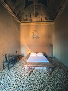 a bedroom with a bed and a chandelier at Palazzo del Settecento in Ravenna