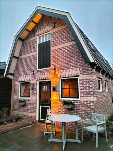 uma casa de tijolos com uma mesa em frente em De oude walnoot em Sint Pancras