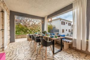 a dining room with a table and chairs on a patio at Apartments LOTA with heated pool on top location in Supetar