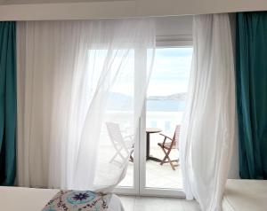 a bedroom with a sliding glass door to a balcony at Grand Beach Hotel in Mikonos