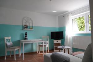 sala de estar con mesa y TV en Ferienwohnung mit Gartenbereich (UT), en Graal-Müritz
