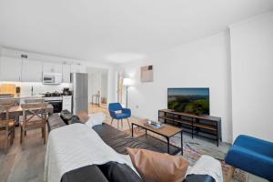 ein Wohnzimmer mit einem Sofa und einem Tisch sowie eine Küche in der Unterkunft 2BR 3BA Beachfront Rental in Town CozySuites in Atlantic City