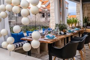einen Tisch und Stühle auf einer Terrasse mit weißen Ballons in der Unterkunft Apartments LOTA with heated pool on top location in Supetar