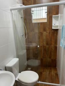 瓜拉圖巴的住宿－Casa região central Guaratuba，一间带卫生间和玻璃淋浴间的浴室