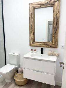 een badkamer met een wastafel, een toilet en een spiegel bij PB Apartamento en pleno centro de Alcoy in Alcoy