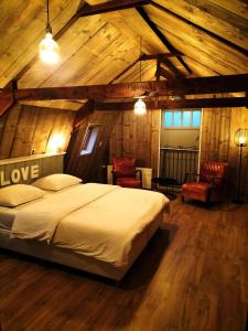 een slaapkamer met een bed en een houten plafond bij De oude walnoot in Sint Pancras