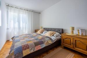 a bedroom with a bed and a dresser and a window at Apartment Sea Star in Kastav
