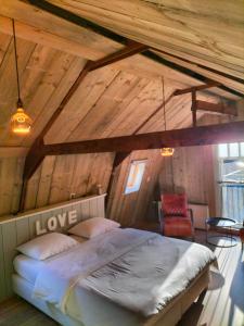 een slaapkamer met een bed op een houten zolder bij De oude walnoot in Sint Pancras