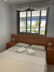 1 dormitorio con 1 cama y 2 toallas blancas en Torredembarra, en Torredembarra