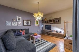 uma sala de estar com um sofá cinzento e uma mesa em Apartments LOTA with heated pool on top location em Supetar
