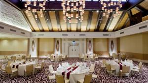 a banquet hall with tables and chairs and a chandelier at Holiday Inn Express Baruna by IHG in Kuta +96 photos
