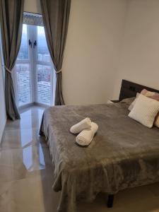 a bedroom with a bed with two white towels on it at Cielo de Benidorm in Benidorm