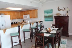 a kitchen with a table and chairs and a counter at Sanibel 406 by ALBVR - Beautiful updates with views that are simply amazing in Gulf Shores