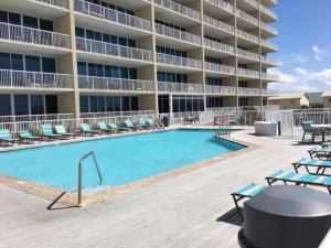 a swimming pool in front of a large apartment building at Sanibel 406 by ALBVR - Beautiful updates with views that are simply amazing in Gulf Shores