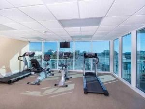 un gimnasio con equipo cardiovascular en una gran sala con ventanas en Sanibel 406 by ALBVR - Beautiful updates with views that are simply amazing en Gulf Shores