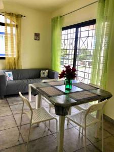 ein Wohnzimmer mit einem Tisch, Stühlen und einem Sofa in der Unterkunft Lovely 2B/1B condo only 5 min walk to the beach. in Bayahibe