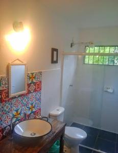 y baño con lavabo, aseo y espejo. en Goura House Ilhabela, en Ilhabela