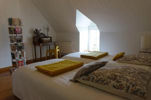 a bedroom with two beds and a window at La Maison de Saint-Dyé in Saint-Dyé-sur-Loire