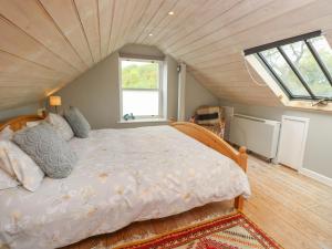 a bedroom with a large bed in a attic at Lower Calbourne Mill in Yarmouth