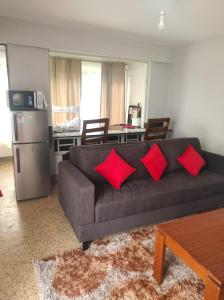 ein Wohnzimmer mit einem schwarzen Sofa und roten Kissen in der Unterkunft Musundi Luxury Homes in Kakamega