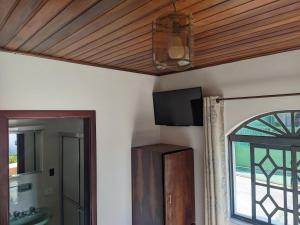 a room with a ceiling with a tv and a window at Pousada dos Marins in Campos do Jordão +19 photos