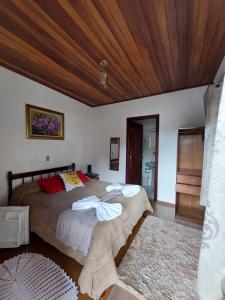 um quarto com uma cama grande e um tecto em madeira em Pousada dos Marins em Campos do Jordão