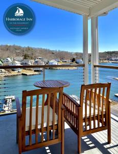 a table and chairs on a porch with a view of the water at Harborage Inn on the Oceanfront in Boothbay Harbor