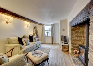 a living room with a couch and a fireplace at Whimbrel Cottage in Appledore