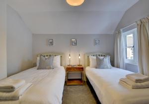 two beds sitting next to each other in a bedroom at Whimbrel Cottage in Appledore