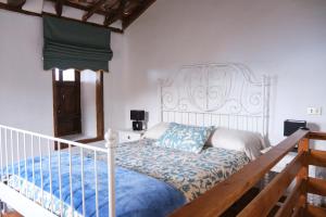 sypialnia z białym łóżkiem i niebieskim kocem w obiekcie Casa Rural Felipe Luis w mieście San Juan de la Rambla