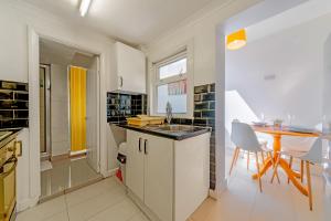 Stylish 3-bed Apartment with Free Parking and Wi-Fi في تشاتهام: مطبخ مع حوض وطاولة في الغرفة