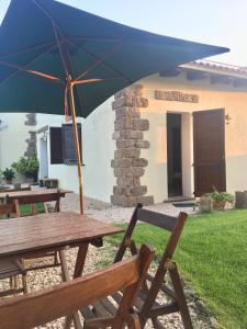 una mesa de picnic con una sombrilla delante de una casa en Artemisia Sardegna en Tergu