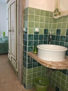 baño con lavabo y pared de azulejos verdes en Artemisia Sardegna en Tergu