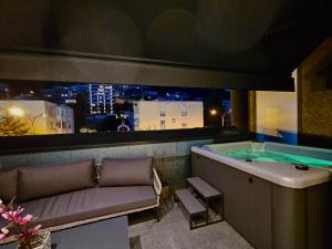a bath room with a tub and a couch and a table at PERLA Apartments in Budva +27 photos
