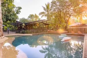 a swimming pool in a backyard with a house at Selina Magnetic Island in Horseshoe Bay