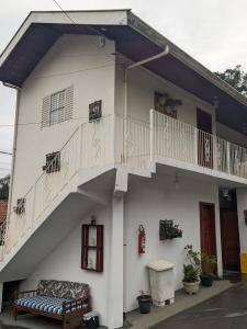 a white building with a staircase and a bench at Pousada dos Marins in Campos do Jordão