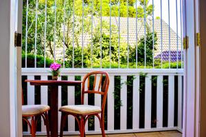 a balcony with two chairs and a table and a window at Chateau do Luar Prime em Campos do Jordao in Campos do Jordão