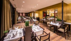 a dining room with white tables and chairs at Wellnesshotel Golfpanorama in Lipperswil