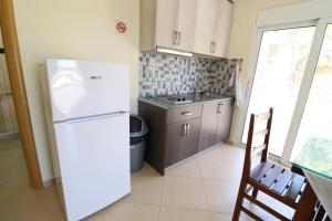 a kitchen with a white refrigerator and a sink at Casa Blanca Rooms in Himare