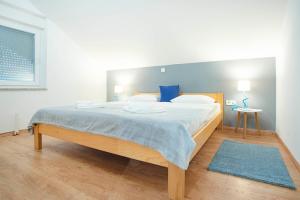 ein Schlafzimmer mit einem großen Bett mit blauen Kissen in der Unterkunft Apartment Roko in Slunj