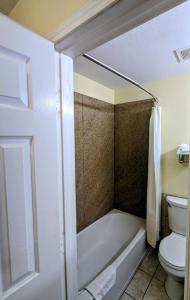 a bathroom with a bath tub and a toilet at Residents Suites Liberty in Liberty