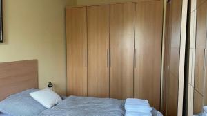 a bedroom with a bed and a large wooden cabinet at Kis-Celli apartman in Budapest