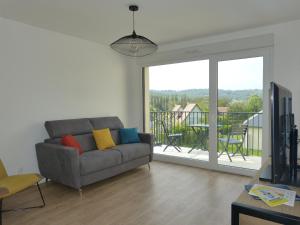 un soggiorno con divano e balcone di Le colibri a Houlgate