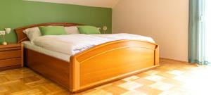 ein Schlafzimmer mit einem Holzbett in einem Zimmer in der Unterkunft B&B Gösselsdorfer Seeblick in Sittersdorf