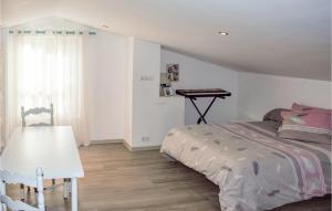 a bedroom with a bed and a table in it at Stunning Apartment In Saint-pe-sur-nivelle With House A Panoramic View in Saint-Pée-sur-Nivelle